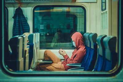 Side view of man sitting on train seat