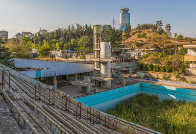 High angle view of swimming pool by building against sky