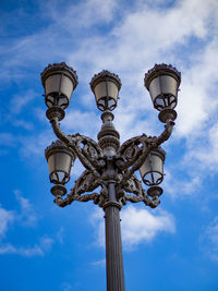 Low angle view of street lamps against sky