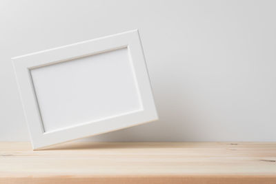 Close-up of empty table against white wall