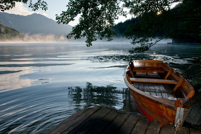 Boat moored on lake against trees