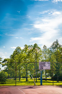 Basketball hoop on field against sky