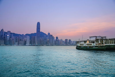 Scenic view of sea and buildings against sky during sunset