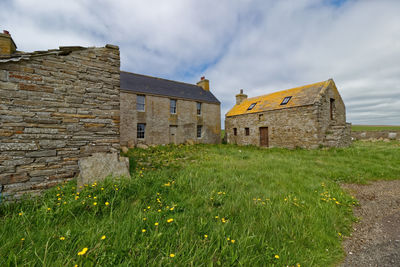 Old ruin building on field against sky