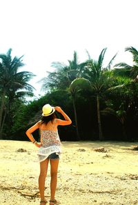 Woman with umbrella standing on beach