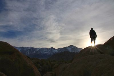 Silhouette of person standing on mountain against sky