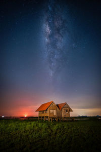 Built structure on field against sky at night