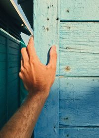 Midsection of person holding blue wall