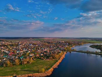 High angle view of river by townscape against sky