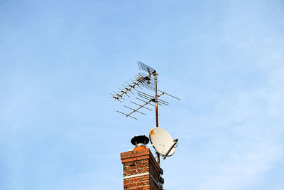 Low angle view of telephone pole against building