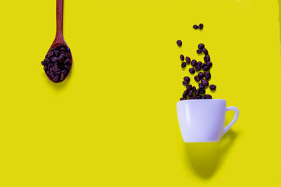 Close-up of coffee cup against yellow background