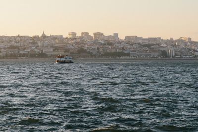 Boats sailing in sea against clear sky