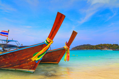 Ship moored on beach against sky