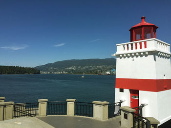 Lighthouse by sea against sky