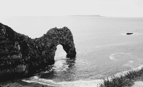 Rock formations in sea against clear sky