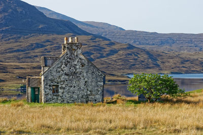 Abandoned house on field against sky