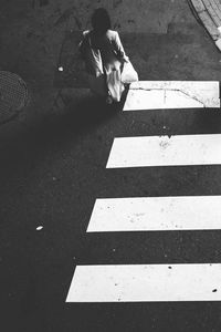 High angle view of man sitting on road