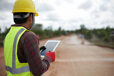 Rear view of man using mobile phone
