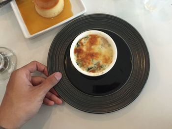 Cropped hand holding plate with food at table