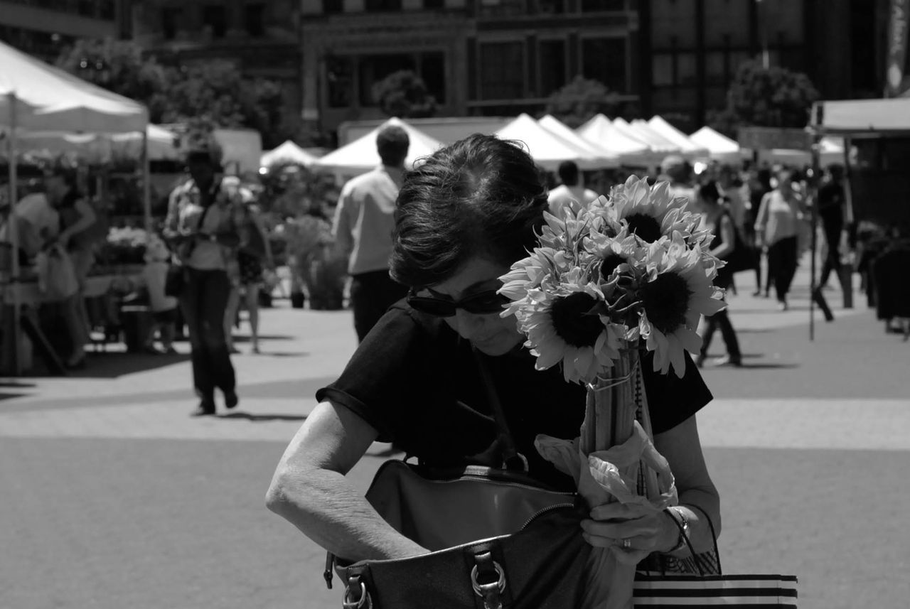 focus on foreground, incidental people, men, person, street, rear view, flower, lifestyles, large group of people, city, leisure activity, day, sitting, outdoors, walking, city life, close-up, road