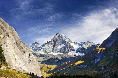 Scenic view of snowcapped mountains against cloudy sky