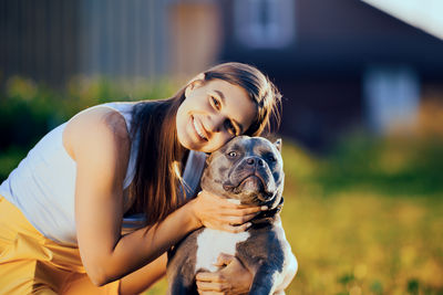 Side view of young woman holding dog