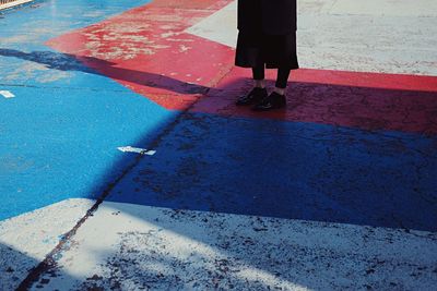 Low section of person standing on footpath