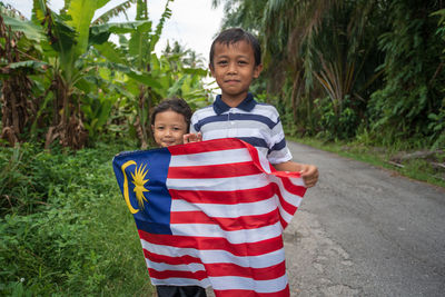 Portrait of smiling boy sitting on land