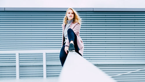 Portrait of woman standing against wall