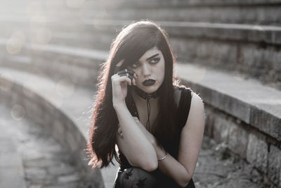 Portrait of beautiful young woman standing against blurred background