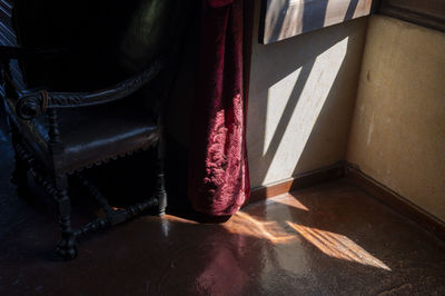 Light entering an old building in italy, lighting a red curtain.