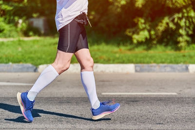 Low section of man running on road