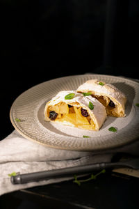 Close up of apple austrian strudel with cinnamon and mint on a plate