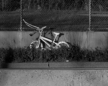 Bicycle by fence on land