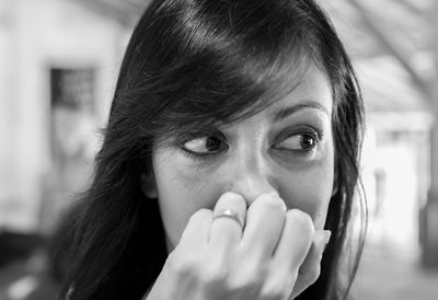 Close-up of beautiful woman covering her mouth