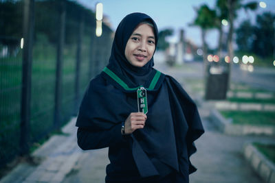 Portrait of smiling young woman standing outdoors