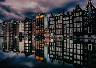 Buildings in city against cloudy sky