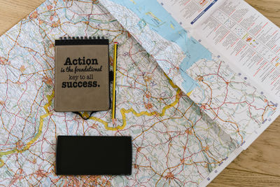 Directly above shot of book with mobile phone on map