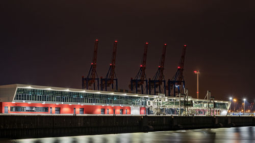 View of illuminated commercial dock against sky at night