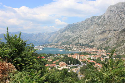 Scenic view of townscape by mountains against sky