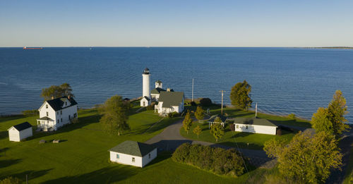 High angle view of buildings by sea against clear sky