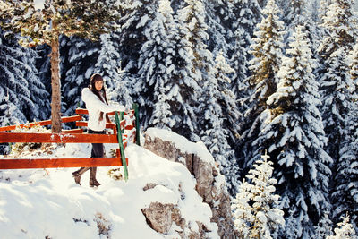 Woman standing on snow covered mountain