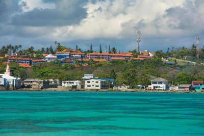 Buildings by sea against sky