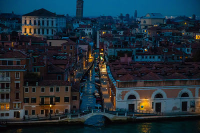 High angle view of river amidst buildings in city at night