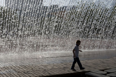 Full length of a boy standing on fountain