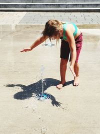 Full length of woman playing with water