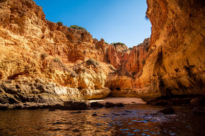 Rock formations in sea against sky
