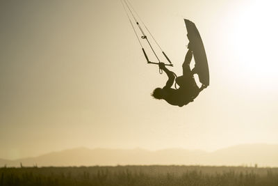 Young male athlete kiteboarding at sunset in la ventana, baja california, mexico