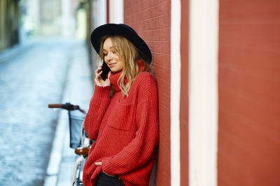 Young woman standing by red umbrella