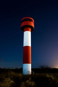 Low angle view of lighthouse against clear sky at night